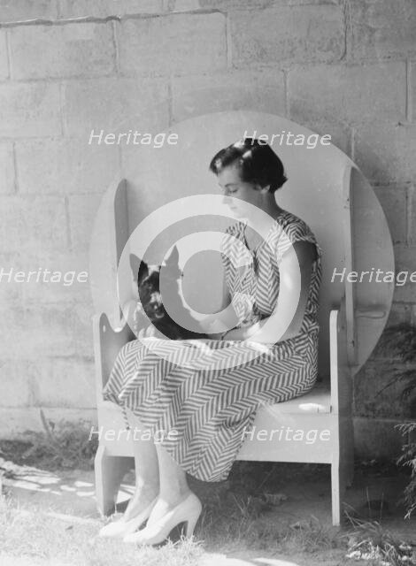 Mrs. Walter Fletcher with dog, seated outdoors, between 1933 and 1942. Creator: Arnold Genthe.
