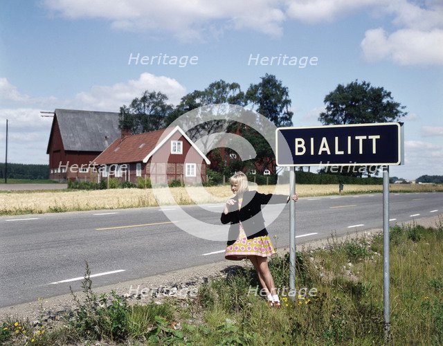Girl by a road sign for Bialitt, Sweden. Artist: Torkel Lindeberg