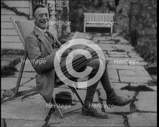 British Chancellor of the Exchequer Joseph Austen Chamberlain Reading a Newspaper While..., 1920. Creator: British Pathe Ltd.