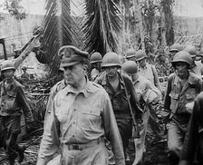 General Douglas MacArthur Walking With American Troops Through Jungle in the Pacific Campaign, 1943. Creator: British Pathe Ltd.