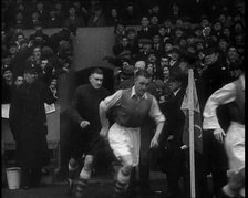 Crowds Watching Football Players Running onto the Football Pitch, 1930s. Creator: British Pathe Ltd.