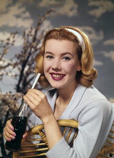 A young woman drinking a bottle of Coca-Cola, c1955.  Creator: Arthur Charles Kirby Ware.