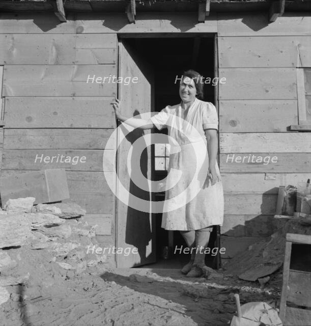 Mrs. Dougherty in doorway of basement house, Warm Springs, Malheur County, Oregon, 1939. Creator: Dorothea Lange.