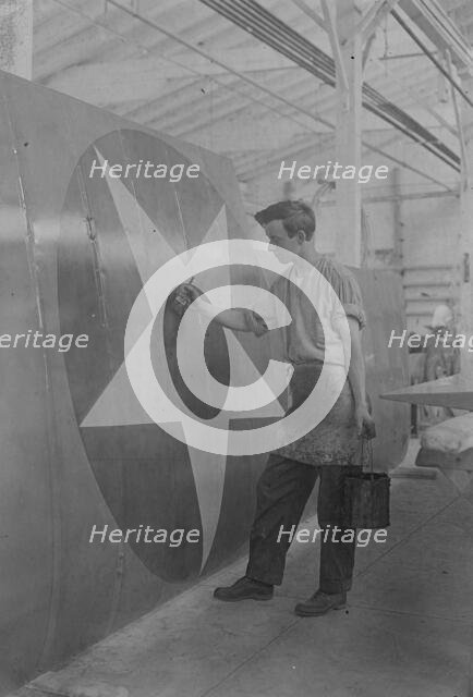 Putting U.S. Emblem on plane, between c1915 and c1920. Creator: Bain News Service.