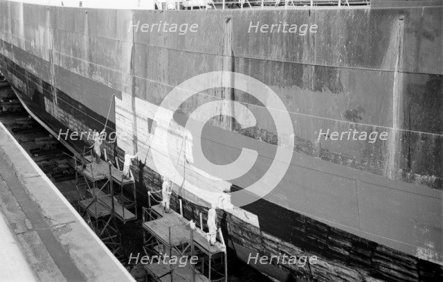 Men paint the hull of a ship in the New Dry Dock, Tilbury Docks, Tilbury, Essex, c1945-c1965. Artist: SW Rawlings