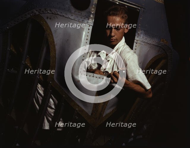 Working inside the nose of a PBY, Elmer J. Pace is learning the...Corus Christi, Texas, 1942. Creator: Howard Hollem.