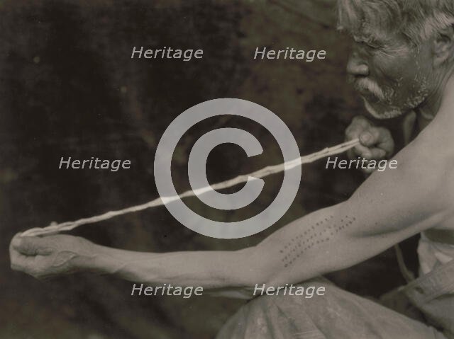 Measuring shell money-Tolowa, c1923. Creator: Edward Sheriff Curtis.