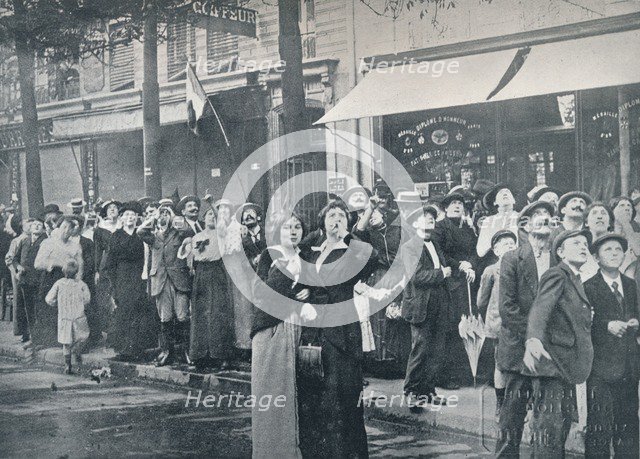 Paris crowd watching one of the German aeroplanes flying over the city, c1914. Artist: Unknown