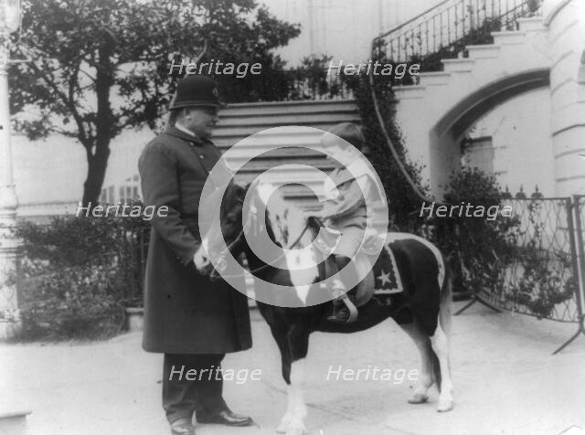 Quentin Roosevelt on pony beside White House policeman, 1905. Creator: Frances Benjamin Johnston.