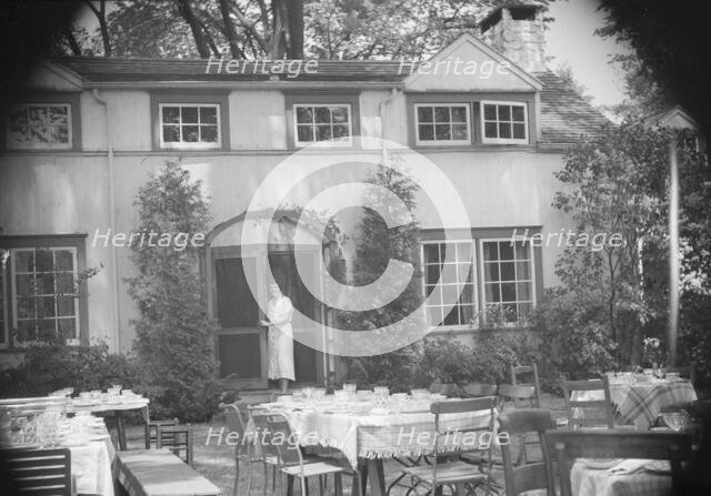 Mrs. Mary Benson standing at the entrance to her house, between 1933 and 1942. Creator: Arnold Genthe.