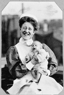 General Lying In Hospital, York Road, Lambeth: nurse sitting holding baby, 1906. Creator: Unknown.