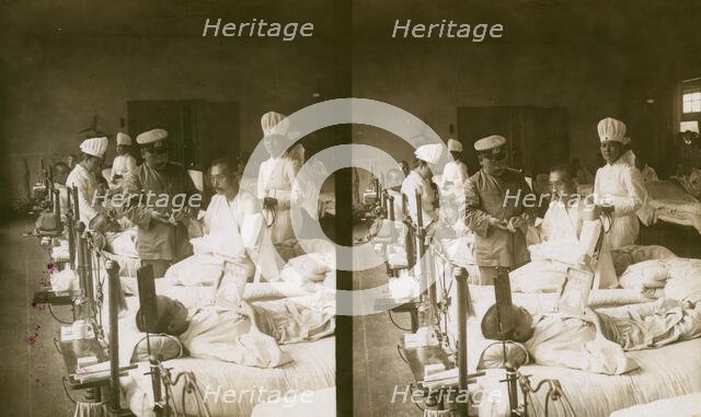 Nurses and a doctor attending wounded soldiers on a hospital ward, c1905. Creator: Underwood & Underwood.