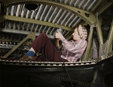 An A-20 bomber being riveted by a woman...Douglas Aircraft Company plant at Long Beach, Calif., 1942 Creator: Alfred T Palmer.
