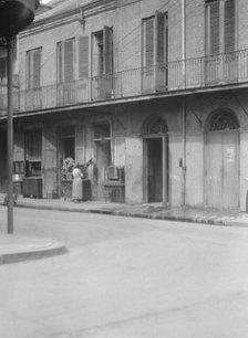 People standing by the doorway of a furniture shop in the French Quarter, New Orleans, c1920-1926. Creator: Arnold Genthe.