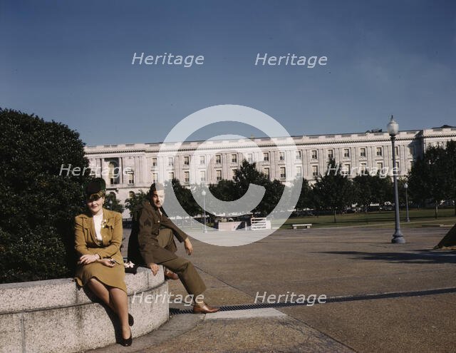 A soldier and a woman in a park, with the Old Russell Senate Office..., Washington, D.C., ca. 1943. Creator: Unknown.