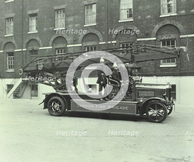 Firemen aboard a fire engine, London Fire Brigade Headquarters, London, 1929. Artist: Unknown.