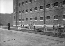 Prisoners cutting grass at Wormwood Scrubs prison, London, c1900-1950. Artist: Unknown