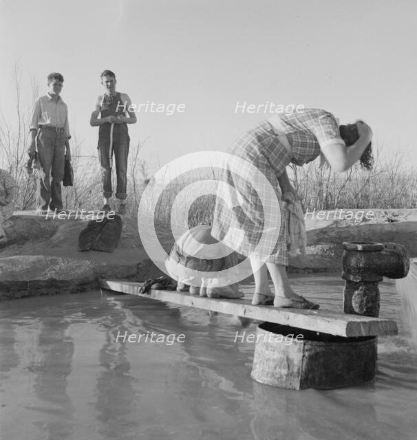 Oklahoma migratory workers washing in a hot spring in the desert, Imperial Valley, California, 1937. Creator: Dorothea Lange.