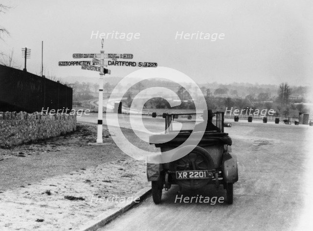 Car near a road sign, Bromley, Kent, 1920s. Artist: Unknown