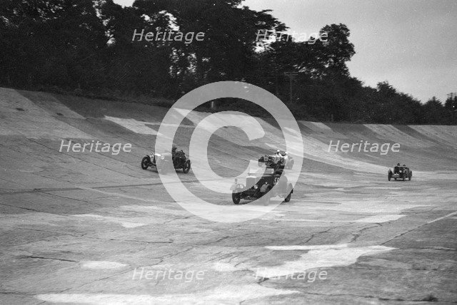 Cars racing on the banking at a JCC Members Day, Brooklands. Artist: Bill Brunell.