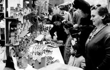 Christmas fair in the Cathedral square in Barcelona, in the foreground manger figures in a shop a…