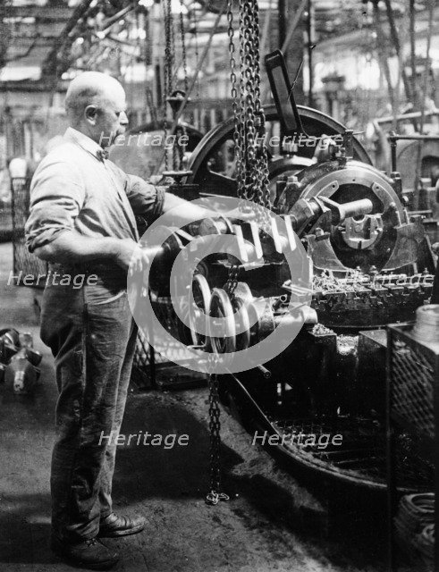 Man operating machinery in a car factory. Artist: Unknown
