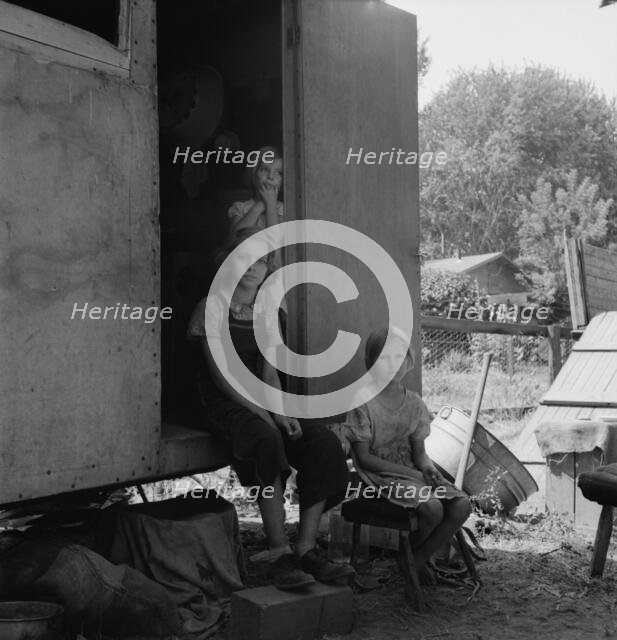 The oldest girl seated in the doorway of the house trailer..., Yakima Valley, Washington, 1939. Creator: Dorothea Lange.