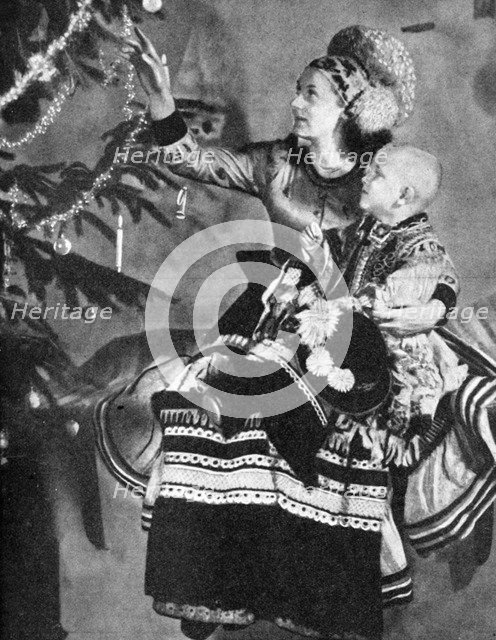 Mother and child with Christmas tree, Matyo people, Miskole, Hungary, 1936. Artist: Unknown