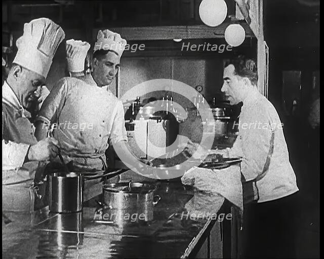 A Galley With Kitchen Staff Cooking and Waiters With Dishes on Board the 'Strength Through..., 1939. Creator: British Pathe Ltd.