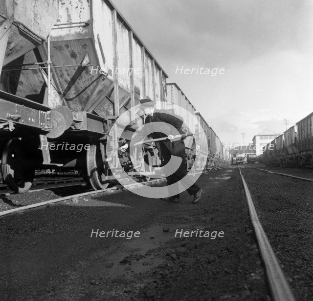 Final adjustments to a rail truck hauling coal from Lynemouth Colliery, Northumberland, 1963.  Artist: Michael Walters