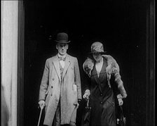 A Male Civilian and Female Civilian Emerging from a Building, 1924. Creator: British Pathe Ltd.