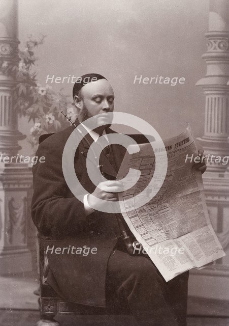 Man reading a newspaper with a long pipe in his hand, Landskrona, Sweden, 1910. Artist: Unknown