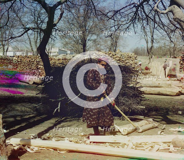 Man using tool to strip logs, Central Asia?, between 1905 and 1915. Creator: Sergey Mikhaylovich Prokudin-Gorsky.