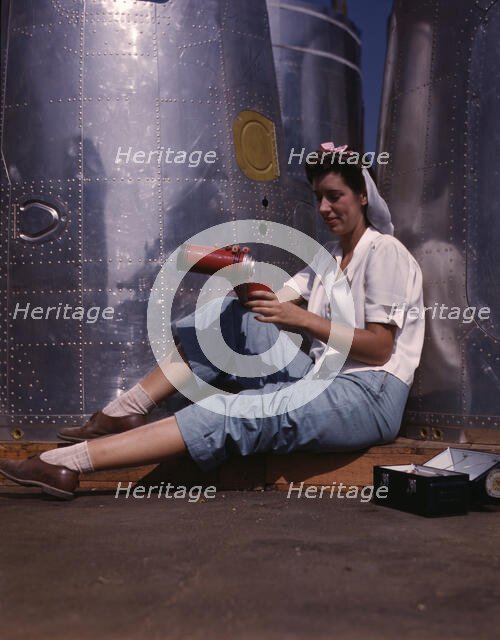 Girl worker at lunch also absorbing Calif..., Douglas Aircraft Company, Long Beach, Calif., 1942. Creator: Alfred T Palmer.