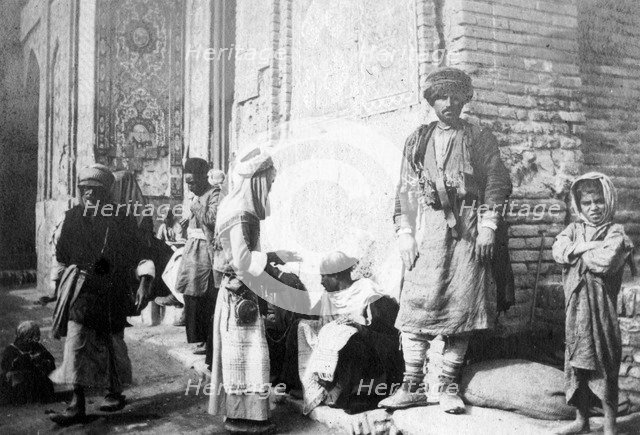 Kurdish barber, outside Kazimain mosque, Iraq, 1917-1919. Artist: Unknown