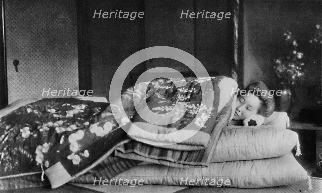 'Saki, the housekeeper sleeps on a mattress with hard pillow under a quilted kimono', c1900, (1921). Artist: Julian Leonard Street.