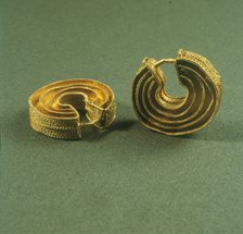 Two gold earrings spiral shaped from the treasure of the Foxardos.