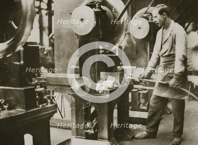 Money making; cutting strips of silver into disks, 20th century. Artist: Unknown