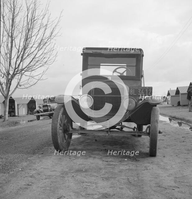 Model T Fords still carry migrants, FSA migratory labor camp at Farmersville, CA, 1939. Creator: Dorothea Lange.
