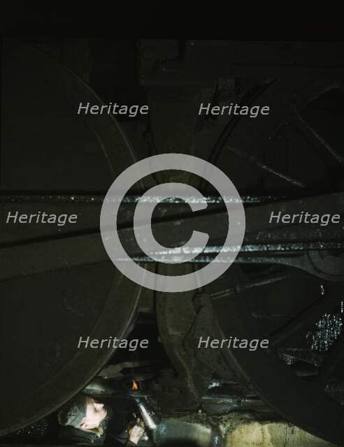 Worker inspecting a locomotive on a pit in the round...C & NW RR's Proviso yard, Chicago, Ill., 1942 Creator: Jack Delano.