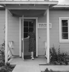 Nurse's help with sick baby, FSA camp, Farmersville, Tulare County, California, 1939. Creator: Dorothea Lange.
