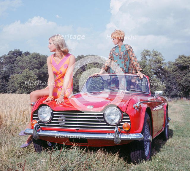 1968 Triumph TR5 with female models, (copyright B.M.I.H.T.). Creator: Unknown.