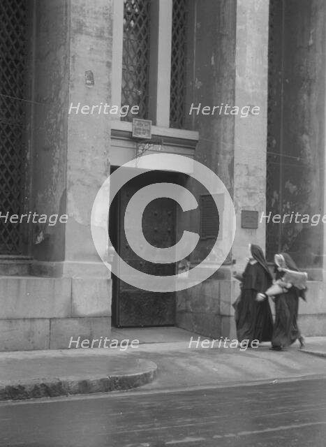 Sisters of Charity and the gateway of the Armory, New Orleans, between 1920 and 1926. Creator: Arnold Genthe.
