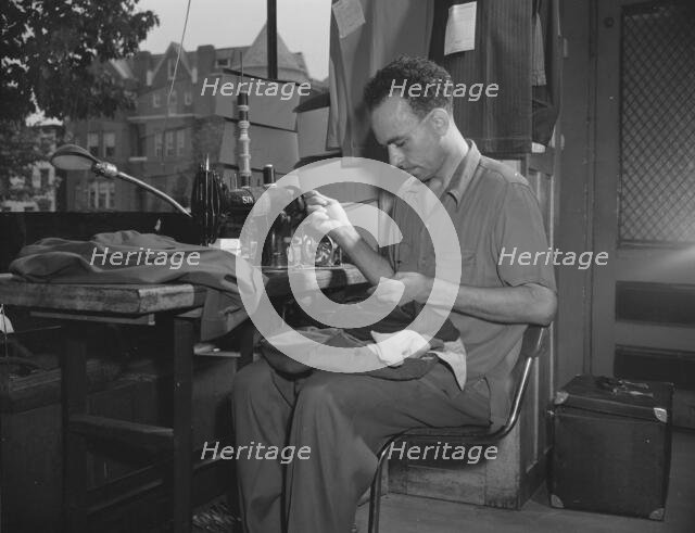 A tailor in Frank's cleaning and pressing establishment altering a pair..., Washington, D.C., 1942. Creator: Gordon Parks.