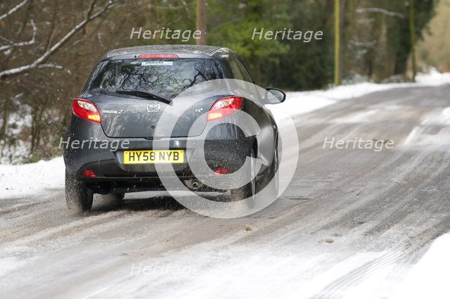 2009 Mazda 2 driving on snowy road Artist: Unknown.