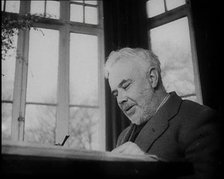 C.E.M Joad Sitting Down at His Desk, 1930s. Creator: British Pathe Ltd.