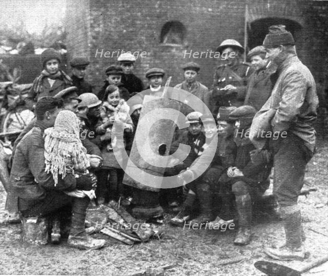 'Delivres ! ; La population enfantine d'un village libere se presse autour d'un brasero improvise pa Creator: Unknown.