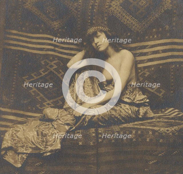 Portrait of a woman, partially draped, seated on a sofa, 1900. Creator: Unknown.