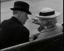 A Rear View of a Elderly Man and Woman Sitting on a Bench and Talking, Both Wearing Hats..., 1938. Creator: British Pathe Ltd.