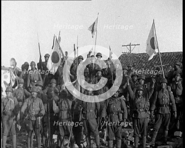 A Group of Male Japanese Soldiers, Many Waving Guns Aloft and Some With Japanese Flags..., 1937. Creator: British Pathe Ltd.